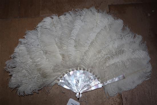 Two white ostrich feather fans, one with gold-monogrammed blond faux-tortoiseshell guard sticks and handle,